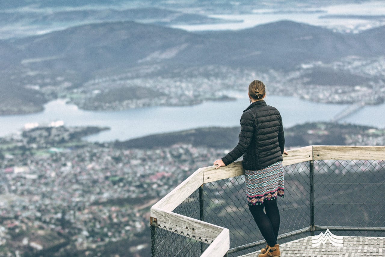 Lady wearing a Tasmanian Tuxedo looking at view of Hobart from Mt Wellington